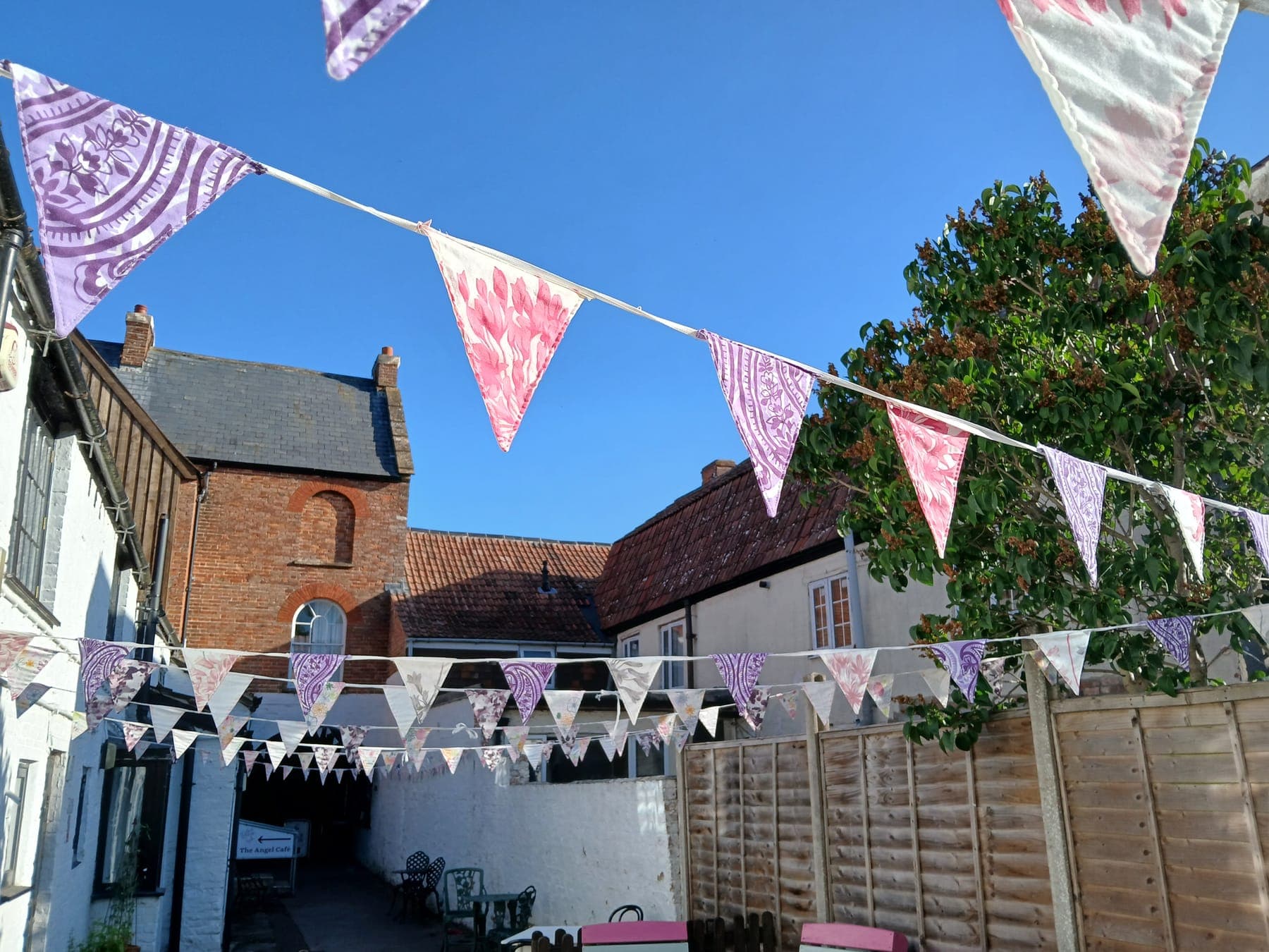 Bunting strung across the courtyard garden at The Angel on a sunny day