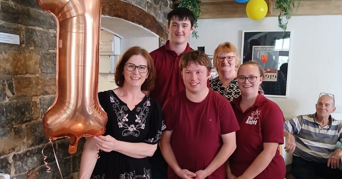 The team at The Angel gathered together for the café's first birthday, with a number one balloon