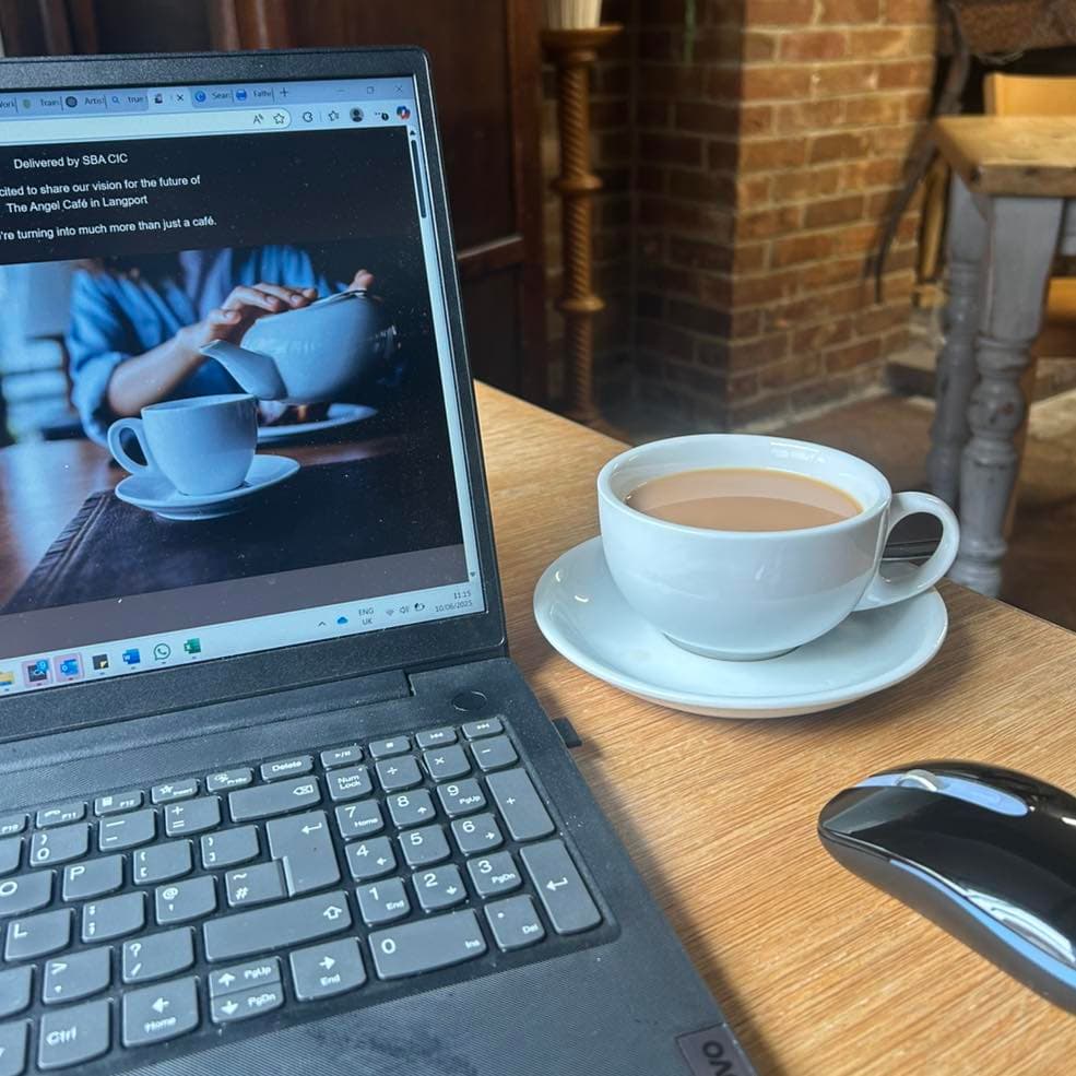 A laptop and a cup of tea on a table in the café